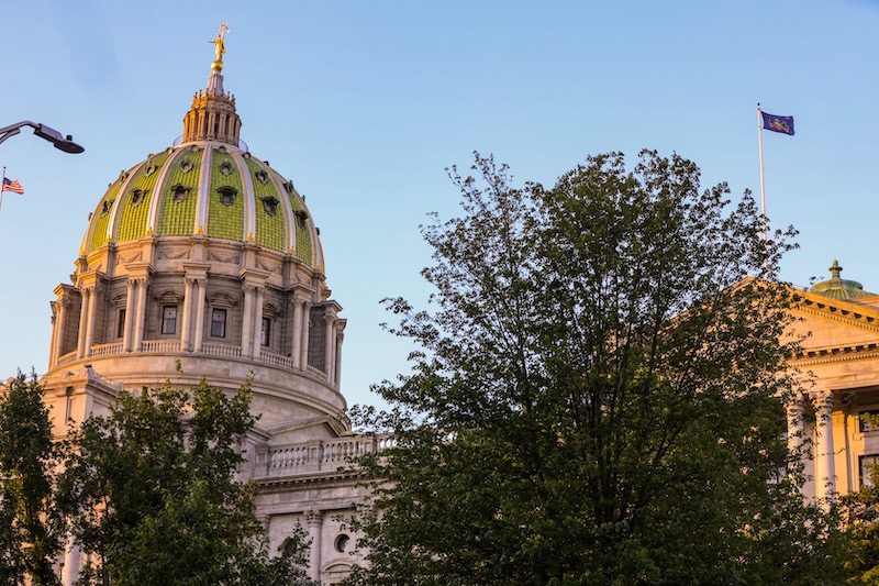 Pennsylvania state capital building in Harrisburg with trees and blue sky